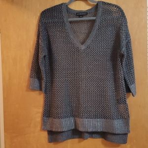 Grey sweater. V neck. Skull shows through on back. Big holes.